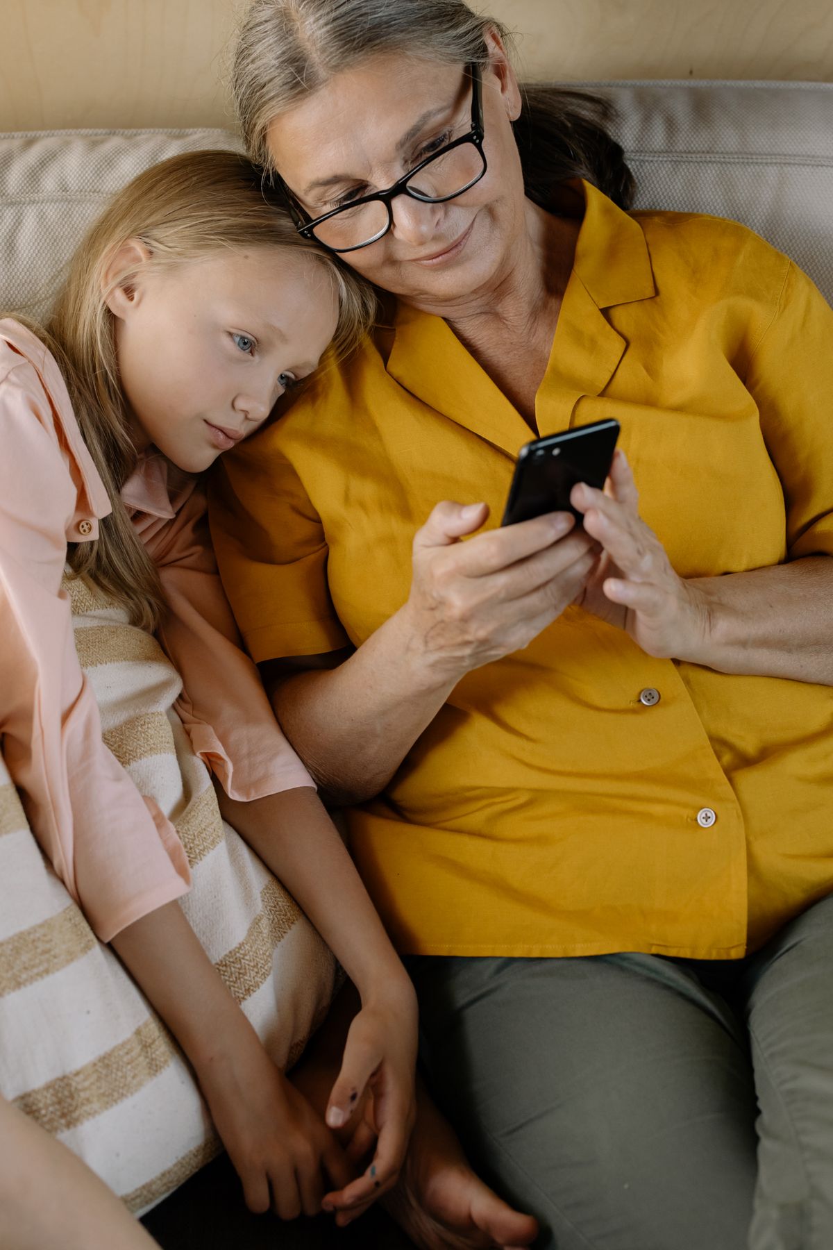 A grandmother and granddaughter sharing a moment with a phone