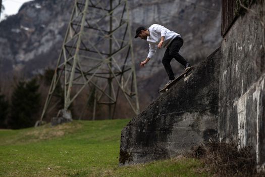 Man Skateboarding From an Inclined Part of an Old Building 