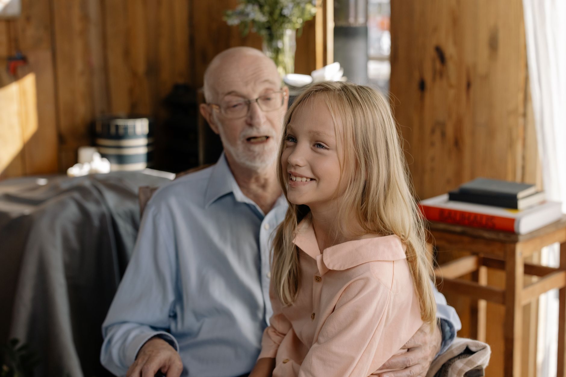 Scène touchante d'un grand-père avec sa petite-fille à l'intérieur, partageant sourires et joie.