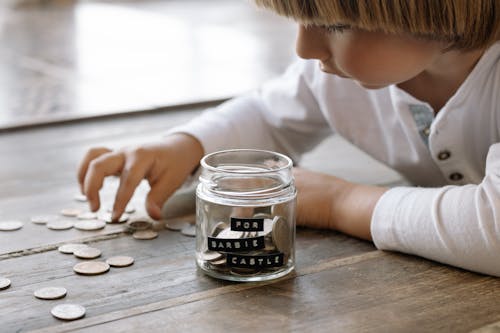 Little Child Playing with Coins on Floor