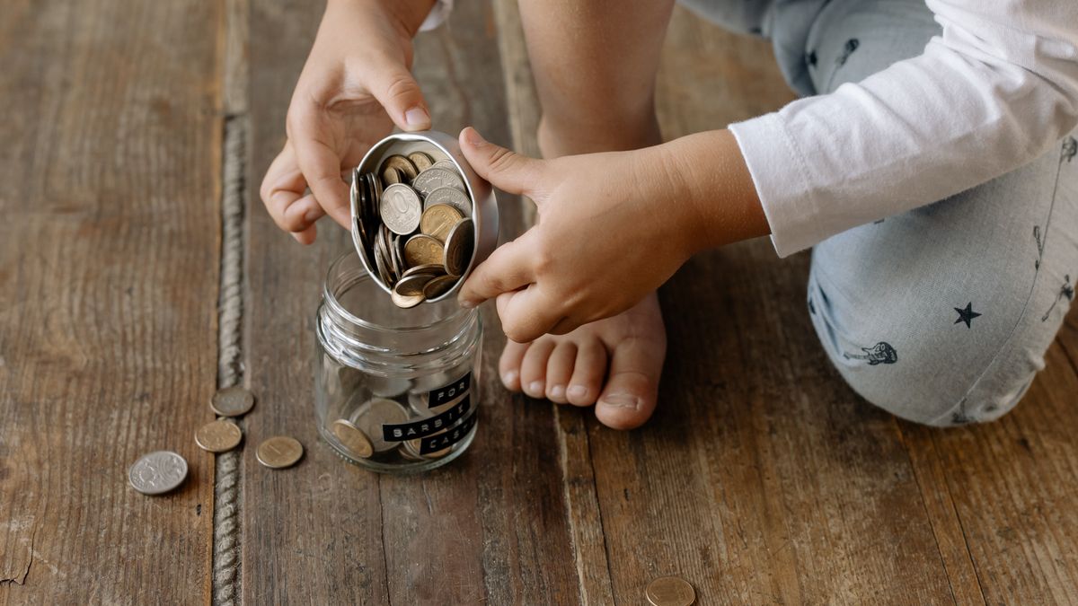 Hands stacking coins next to a piggy bank