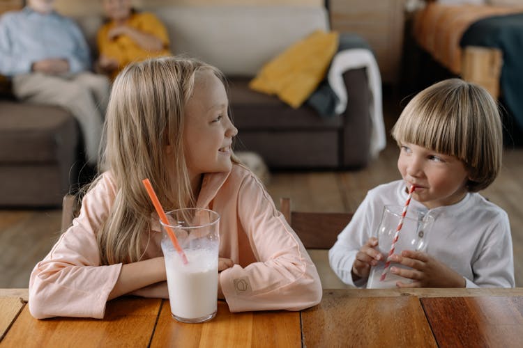 A Girl And Boy Drinking Milk Together 