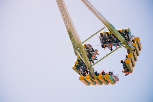 Free Photo of People Riding a Green and Yellow Amusement Ride Stock Photo