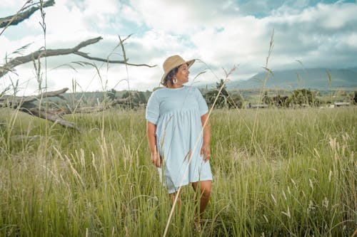 Free Woman in White T-shirt Dress Standing on Green Grass Field Stock Photo