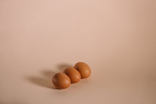 Three Brown Eggs on White Surface