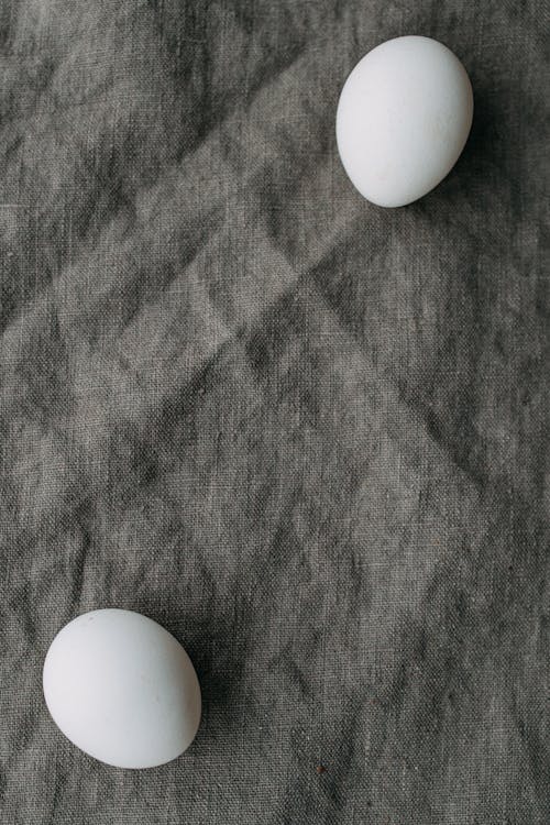 Photograph of White Eggs on a Gray Textile