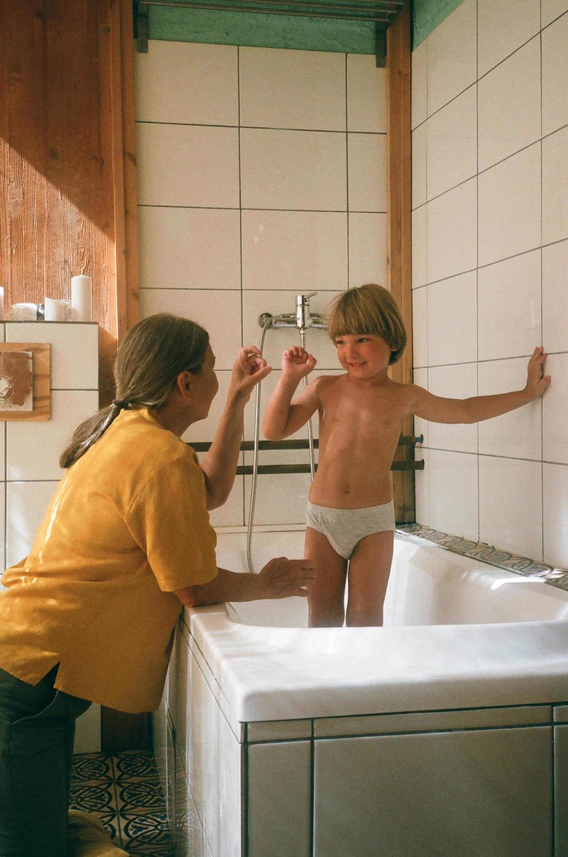 a kid standing in the bathtub