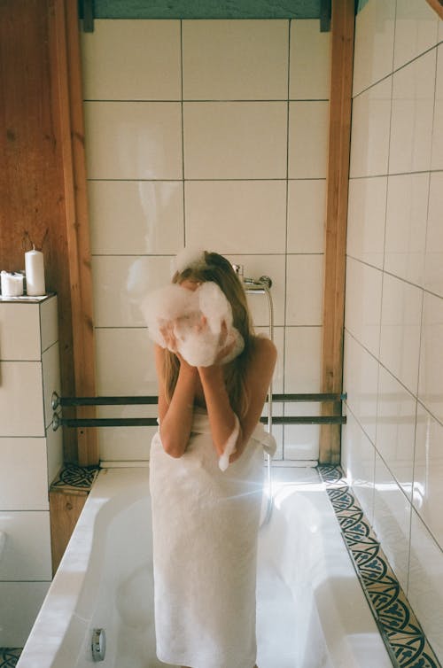 Photo of a Girl Putting Bubbles on Her Face