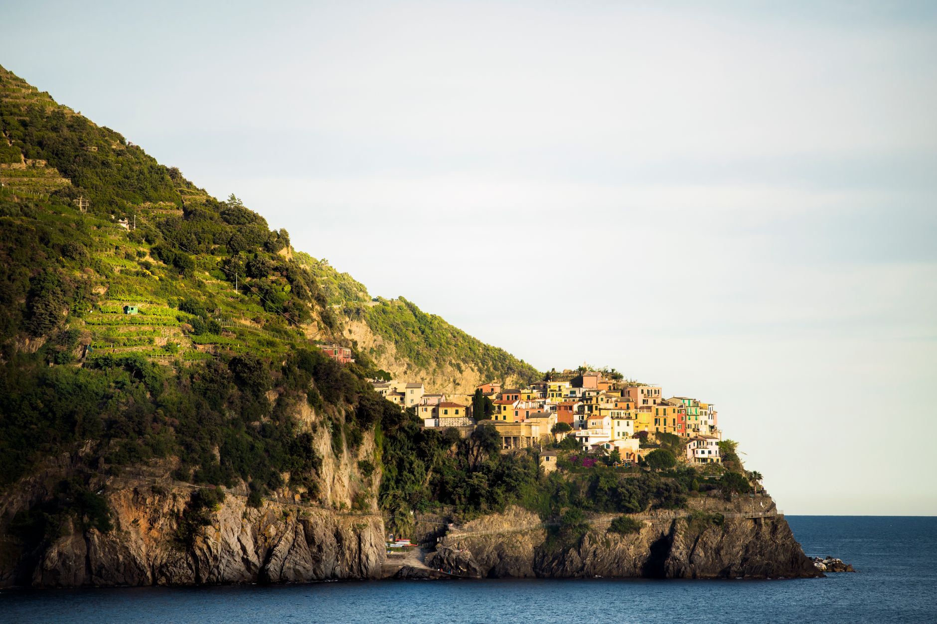 Hiking In Italy Cinque Terre 6 A stunning view of the colorful Manarola village perched on rugged cliffs in Liguria, Italy.