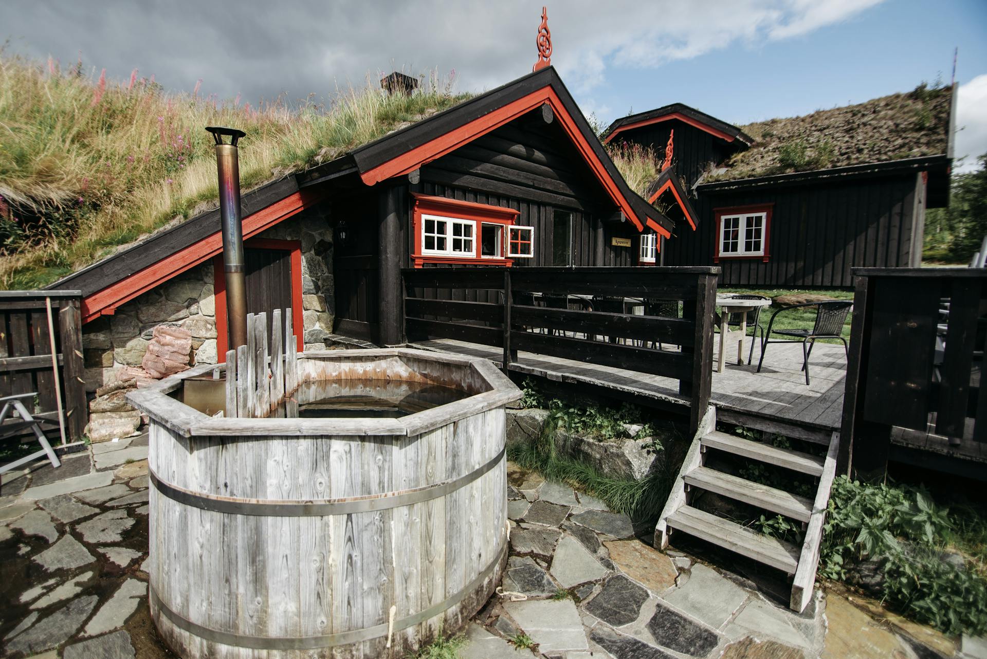 Brown Wooden House with a Porch and an Outdoor Tub
