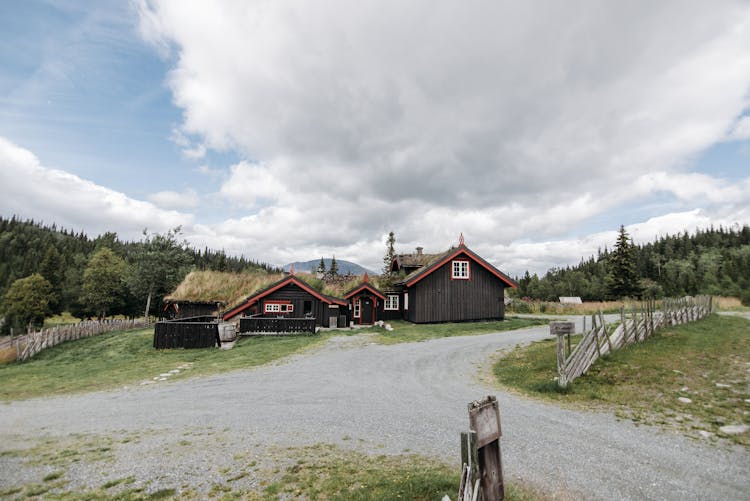 Wooden House And Barn Near An Unpaved Road