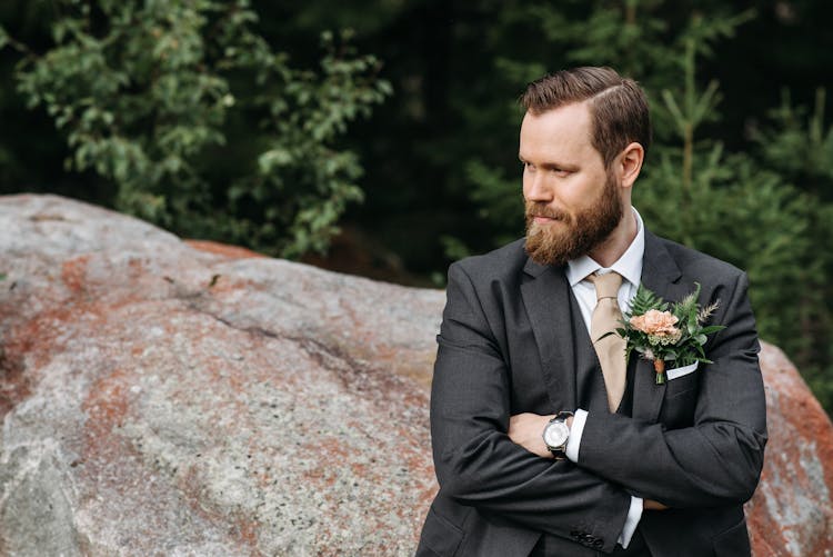 Man In A Black Suit Crossing His Arms While Looking Away