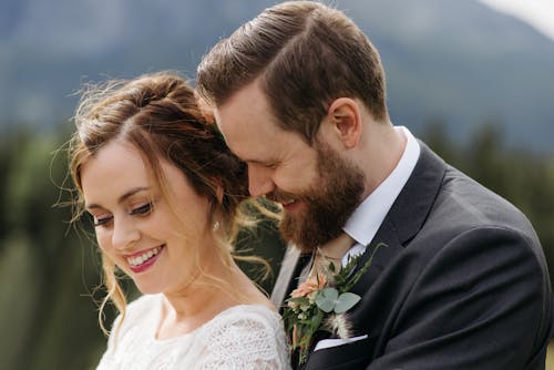 Close-Up Photo of a Groom and a Bride Smiling Together