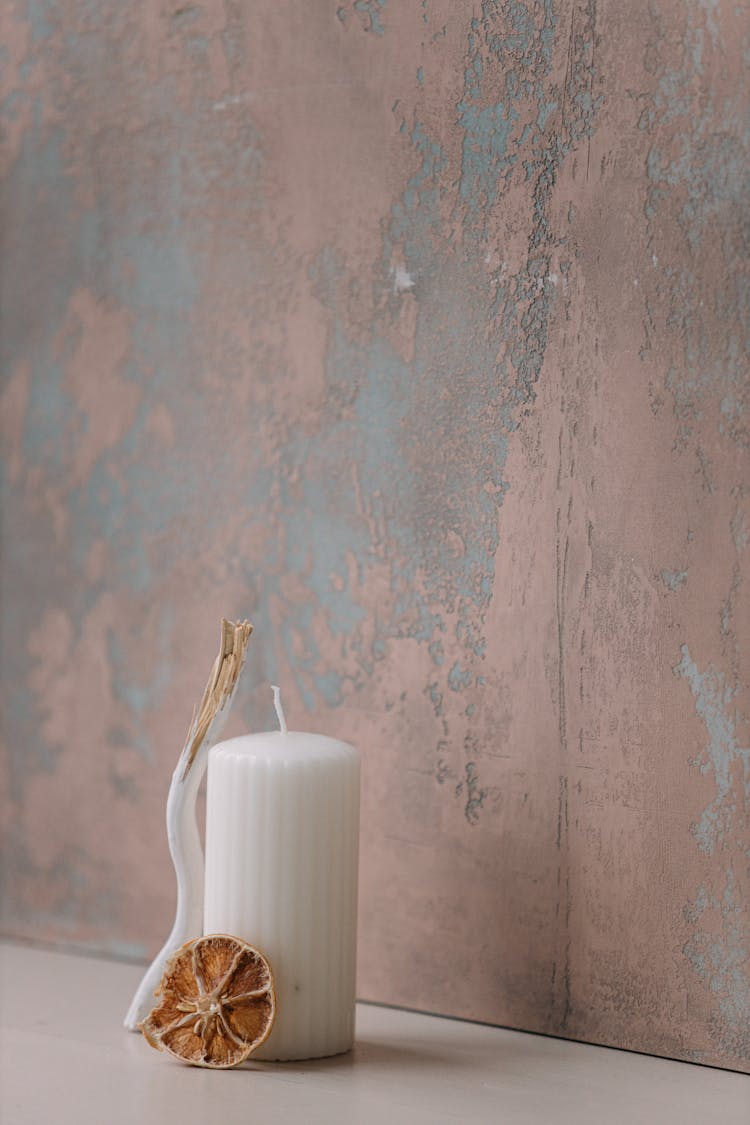 Dried Lemon Slice Beside The Candle On A White Surface