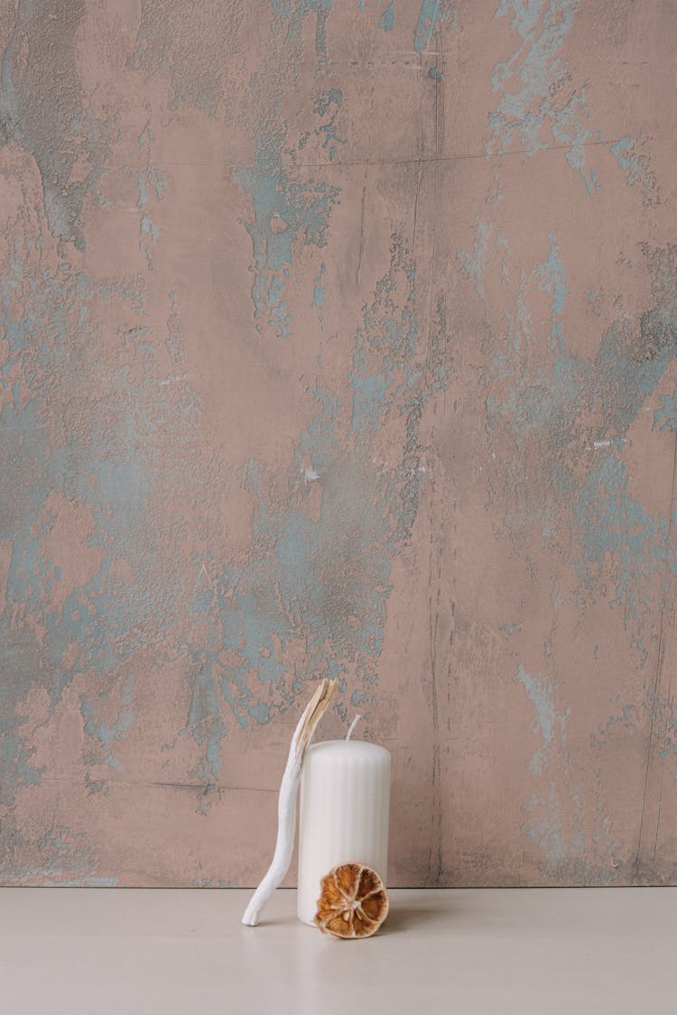 Dried Lemon Slice And Stick Beside Candle On A White Surface