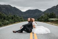 Man in Black Suit Sitting on Road