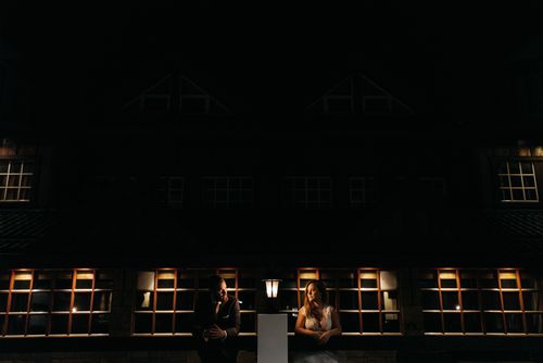 Free A dramatic photo of a couple illuminated by lamps against a dark backdrop. Stock Photo