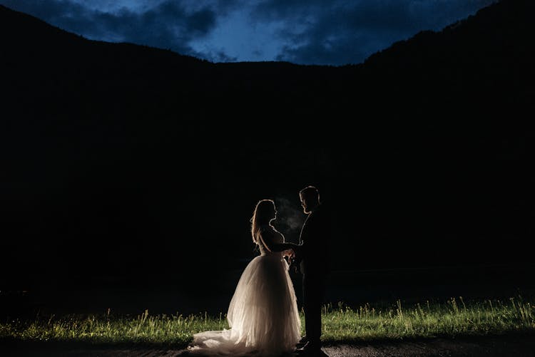 Couple Standing Beside Silhouette Of The Mountain