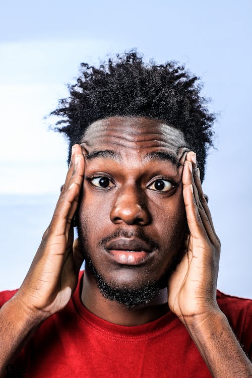 Free Portrait of a Man Looking Shocked, Frowning and Holding His Temples  Stock Photo