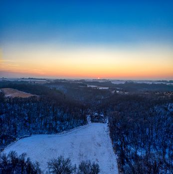 Scenic aerial view of a snow-covered winter landscape during a vibrant sunset in Minnesota.