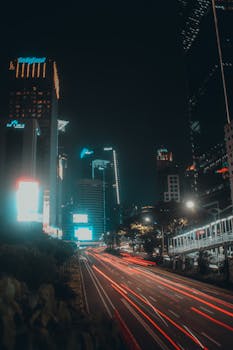 Vibrant Jakarta cityscape at night featuring skyscrapers and light trails from traffic.