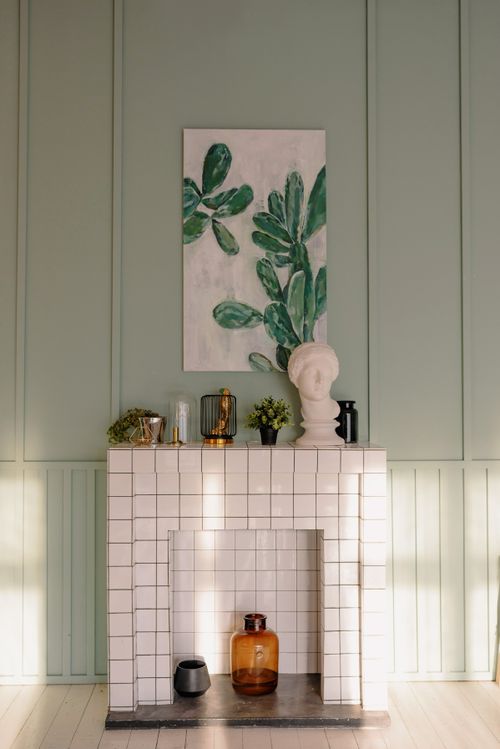 Free Elegant living room with a tiled fireplace, decor, and green accent wall. Stock Photo