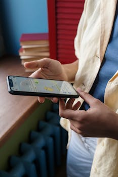 Close-up of a person using a smartphone indoors, focusing on online communication and technology.