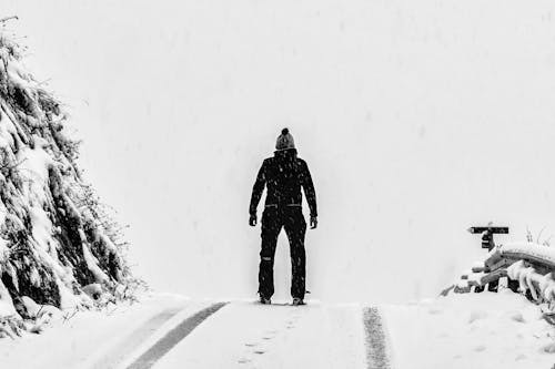 Free Man Standing on White Snow Covered Ground Beside Mountain Stock Photo