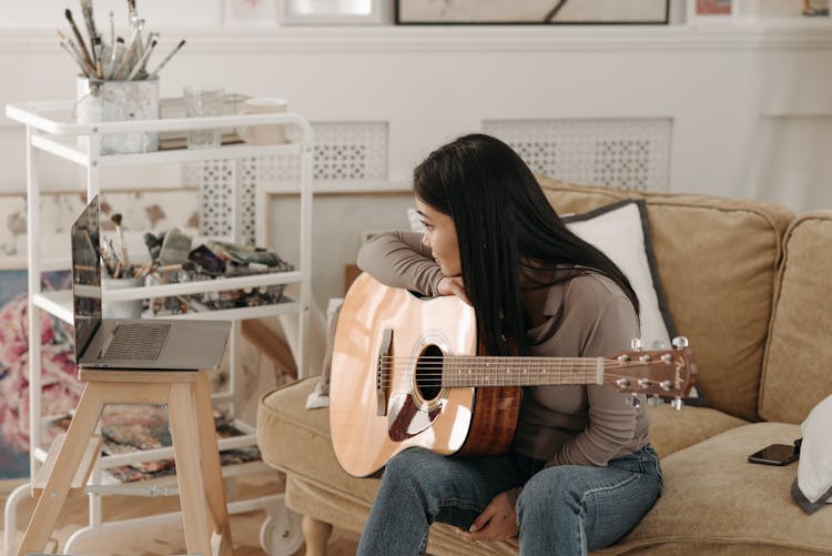 Woman Learning How To Play A Guitar