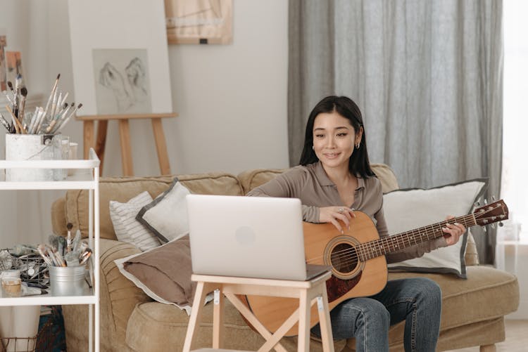 Woman Learning How To Play A Guitar