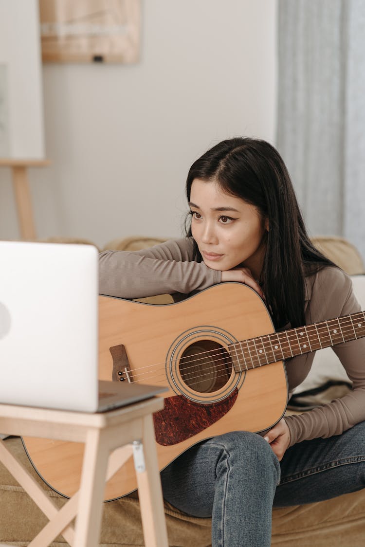 Woman Learning How To Play A Guitar