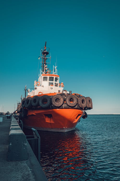 Free An Orange Tugboat Docked on a Harbor Stock Photo