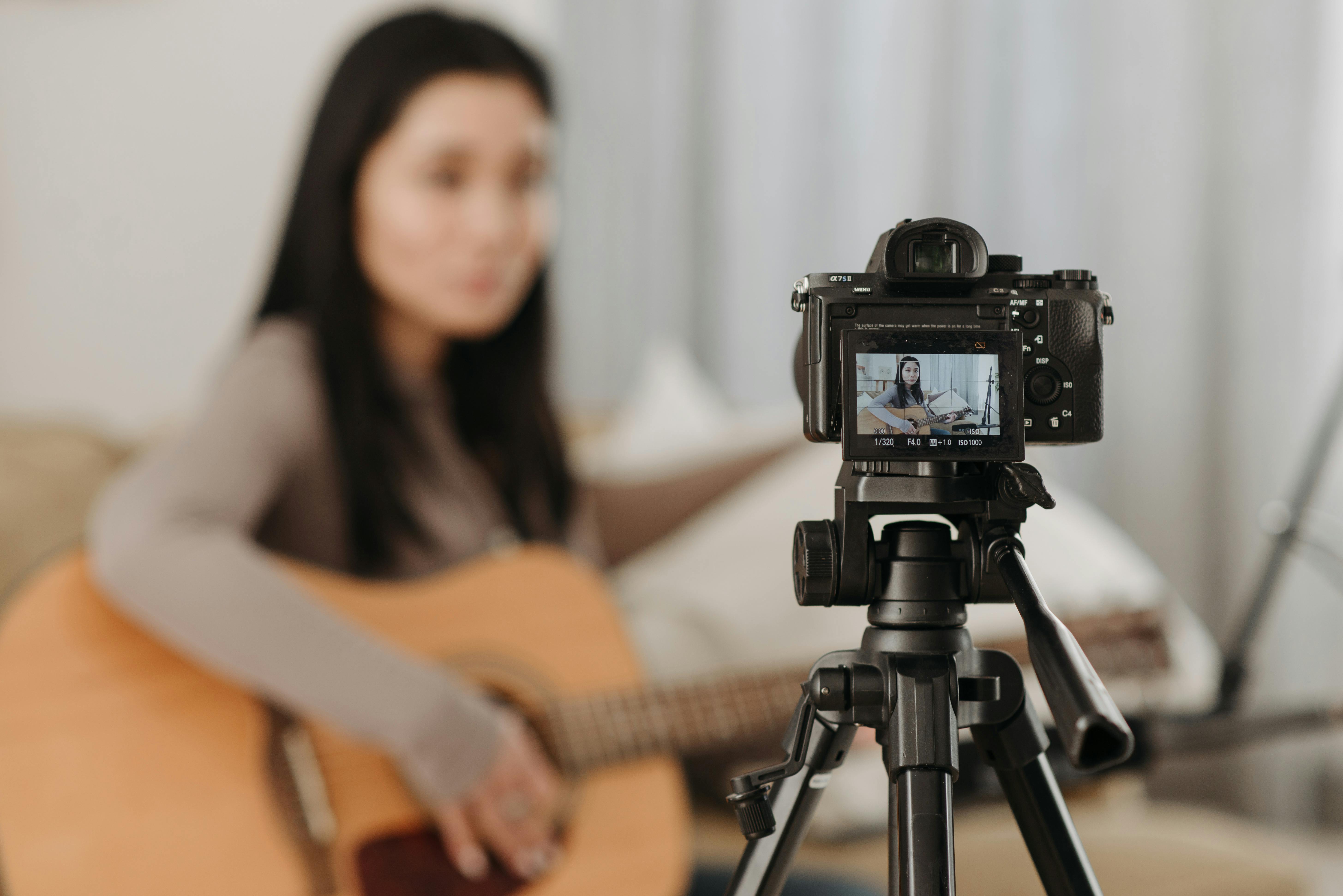 A camera recording a person playing a guitar