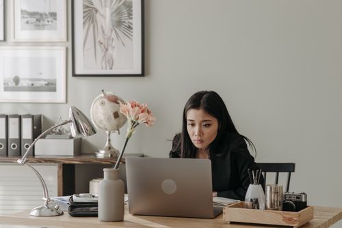 Free A woman concentrates on her laptop in a stylish home office setup with elegant decor. Stock Photo