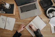 A Person Writing on a Notebook