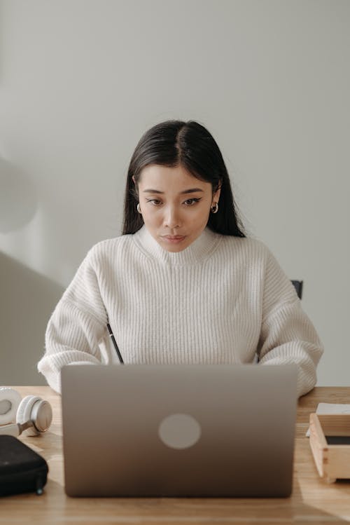 Free Woman in White Turtleneck Sweater Using Silver Macbook Stock Photo