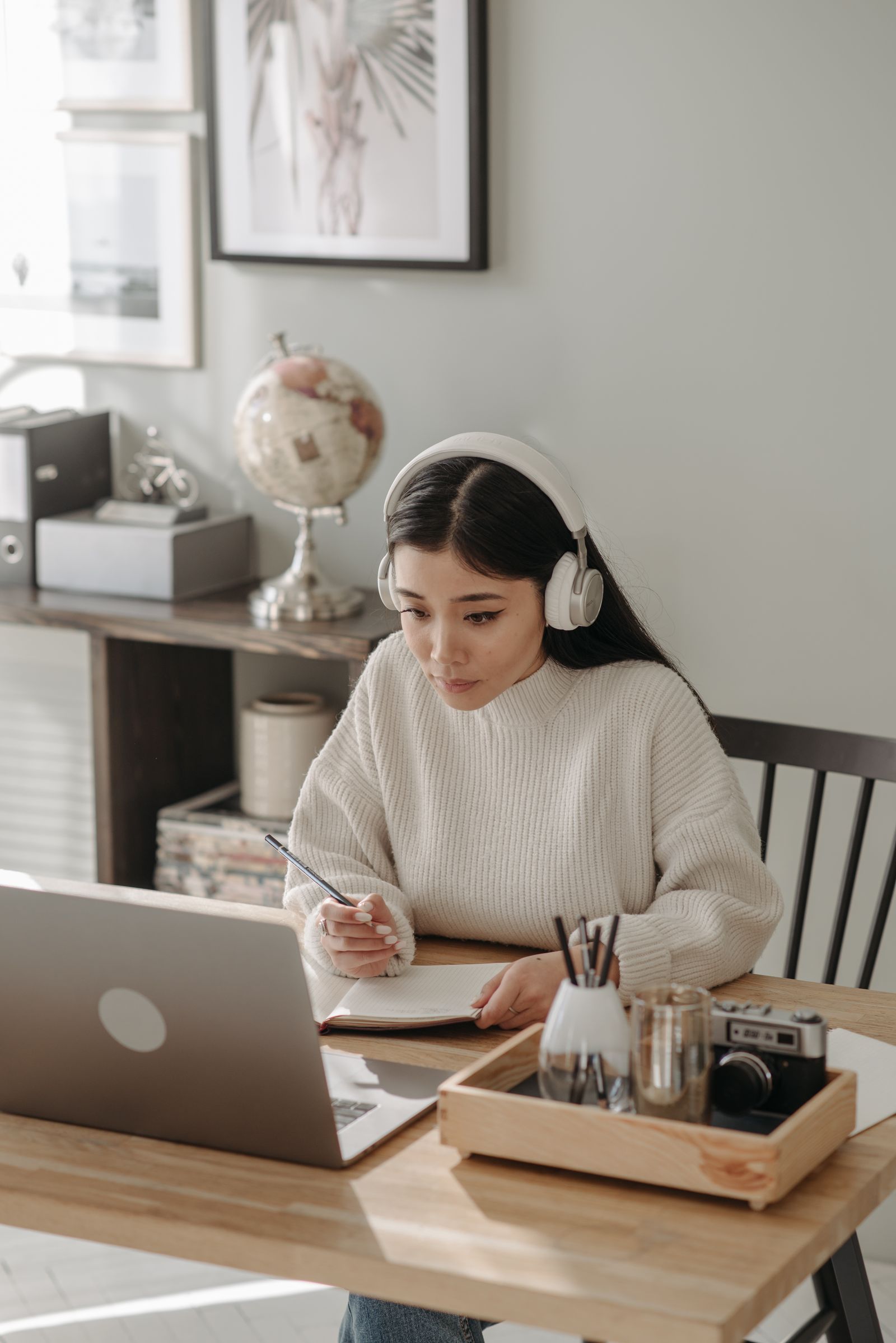 Student wearing headphones focused on studying at a desk