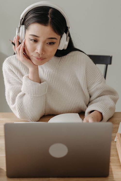 Woman with White Headphones Working on Her Laptop · Free Stock Photo