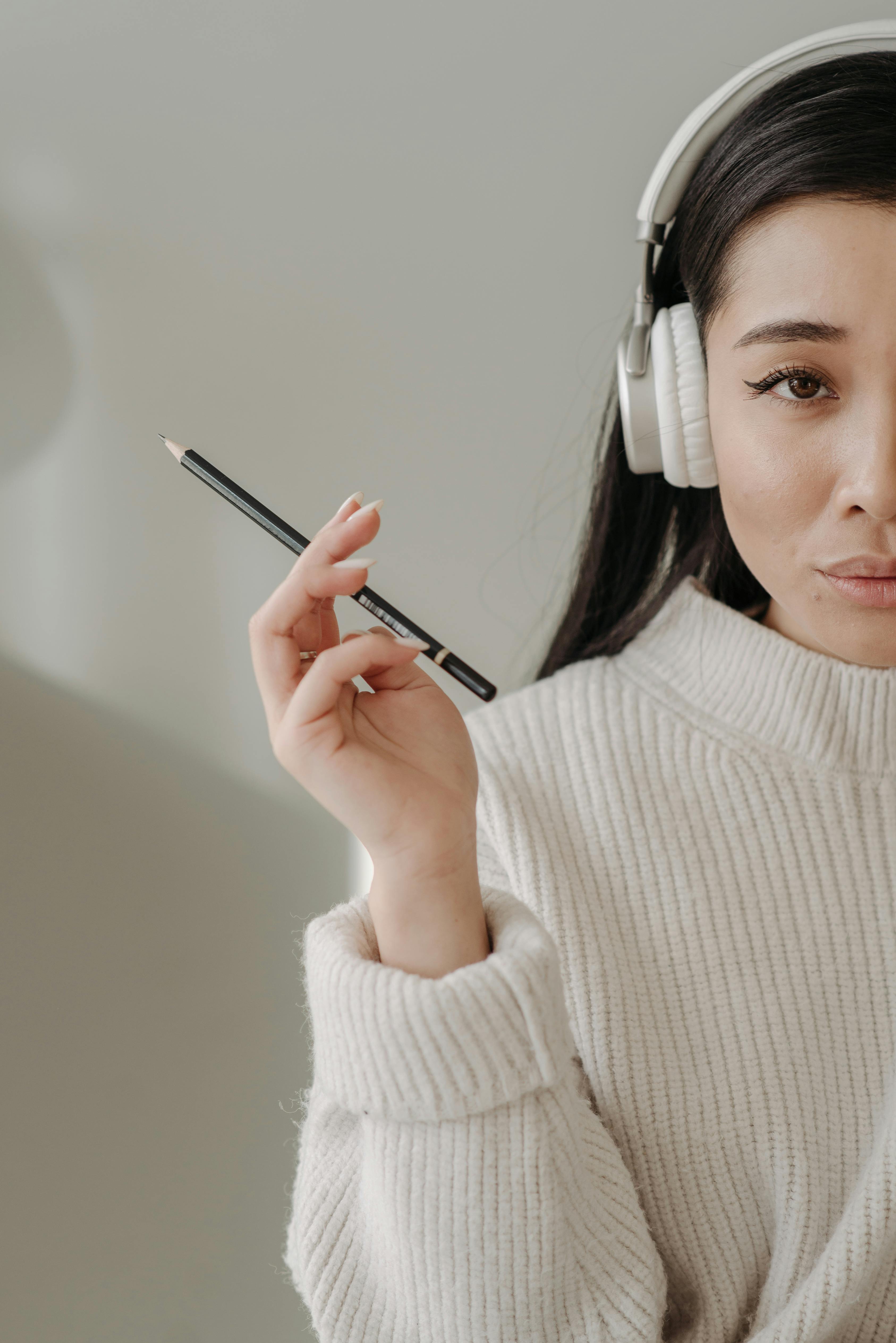 woman in white knit sweater holding black pencil