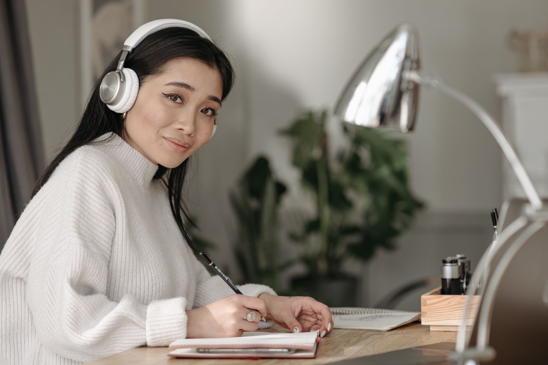 brown noise ADHD brown noise white noise — woman wearing headphones at desk cozy study setup warm lamp