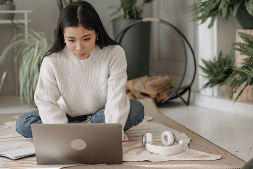 Woman with White Headphones Working on Her Laptop · Free Stock Photo