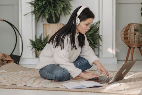 Woman with White Headphones Working on Her Laptop · Free Stock Photo