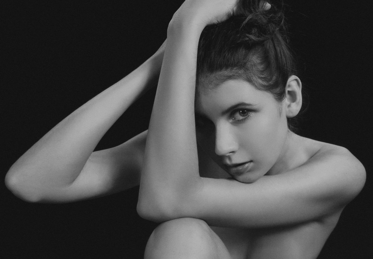 artistic black and white close up of a woman in a thoughtful pose exud