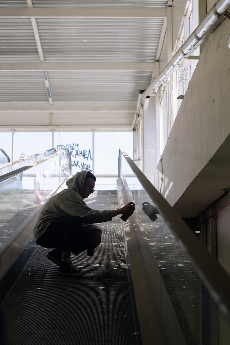 A Man Doing Vandalism On The Walkalator Glass