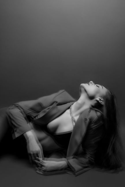 Artful monochrome portrait of a woman posing gracefully in a studio setting.
