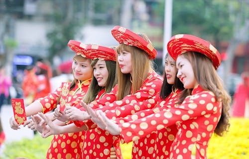 пять женщин в красно белом платье Cheongsam в горошек стоят