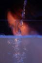 Faceless lady near glass container with turbid water with bubbles in dark room