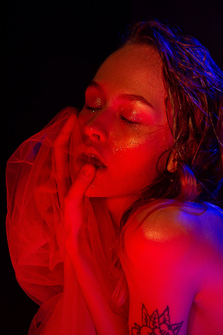 Dreamy Female With Shining Face And Textile In Dark Room