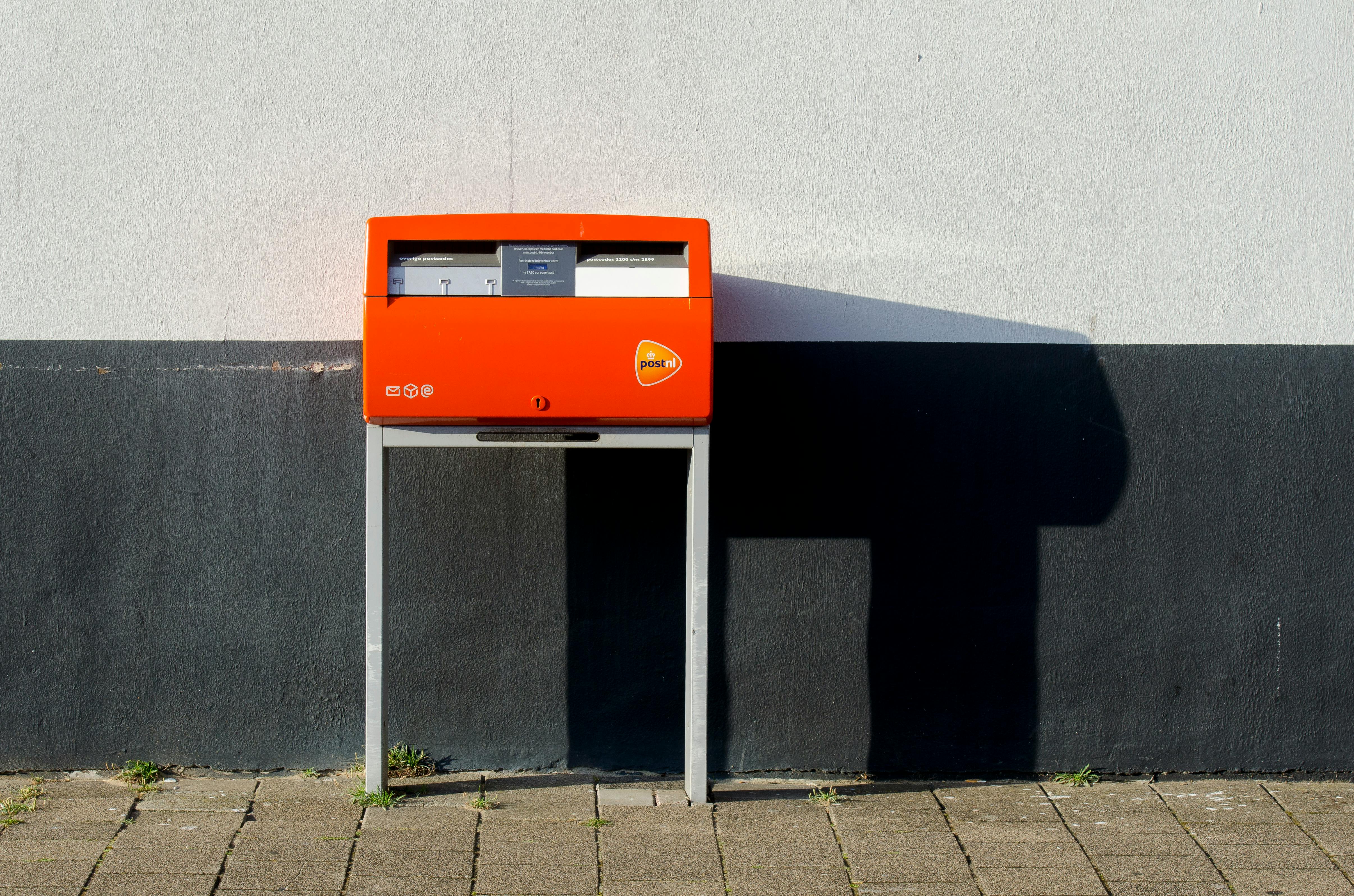 a postnl mailbox near a wall