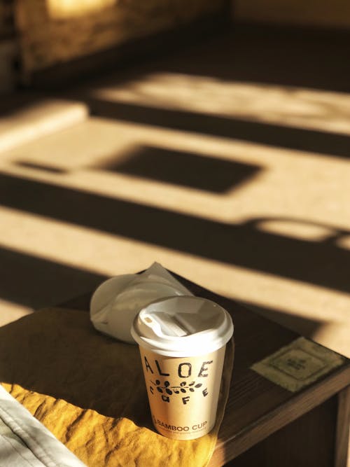 Free Coffee in a Take Out Cup on a Bench Stock Photo